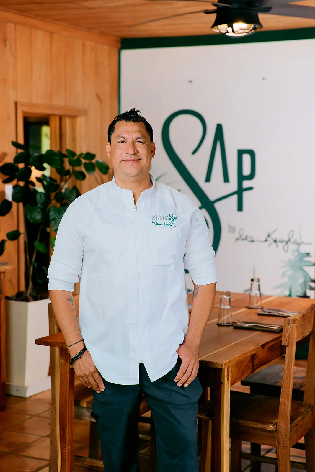 chef in white clothing in front of sap sign