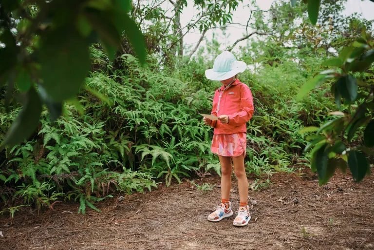 kid in belize forest looking at map